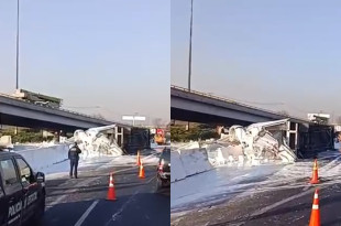 Servicios de emergencia trabajan en el retiro de un tráiler volcado y el derrame de pintura blanca