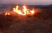 En Tejupilco policías municipales y personal de Protección Civil trabajan para sofocar el incendio registrado en el libramiento oriente