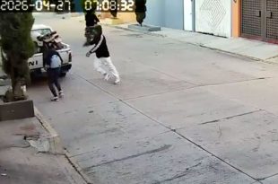 Momento exacto en que uno de los sujetos encañona a la mujer para despojarla de sus pertenencias, mientras su cómplice espera en motocicleta para huir en Chimalhuacán.