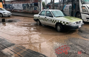 "Ahogan" baches la calle frente a escuela preparatoria en Toluca